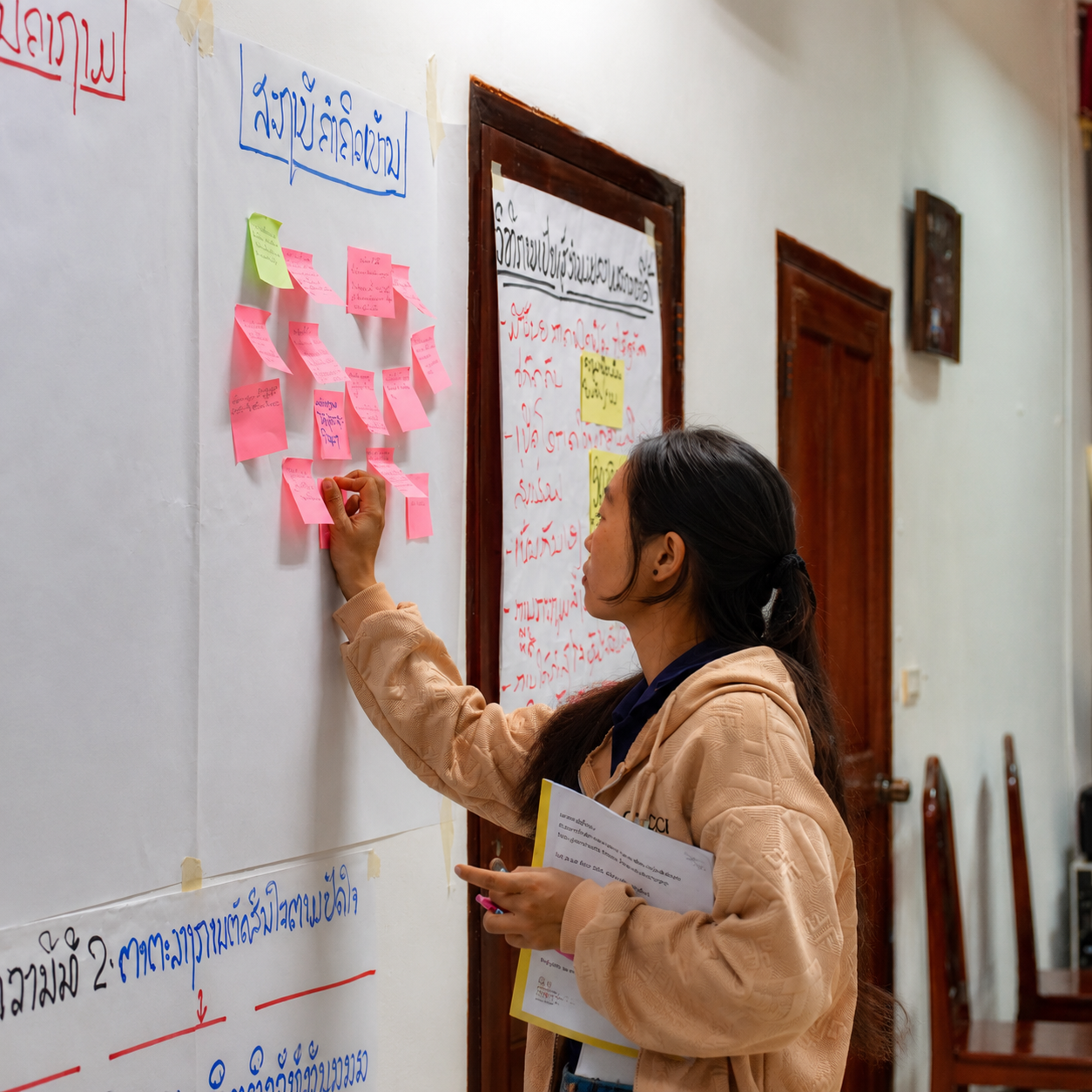 Woman placing sticky notes during a participatory learning workshop